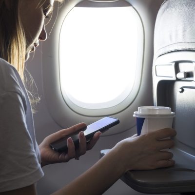 girl-holding-coffee-looking-phone